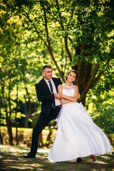 Casal jovem, noiva e noivo andando e desfrutando de seu dia de casamento. Luz do sol. Verão . — Fotografia de Stock