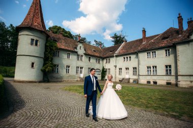 Yeni evliler düğün gününde parkta yürüyorlar. Gelin ve damat Enjoying düğün gününde. Güneşli havalarda. Bahar.