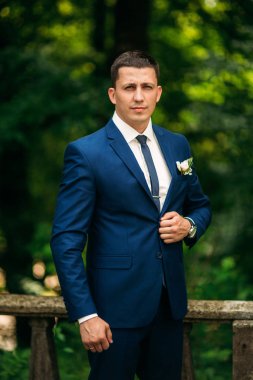 Damat takım elbiseli evde giyindi. Şirin damat bir fotoğrafçısına poz