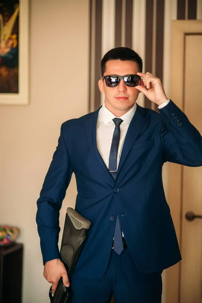 The groom is dressed at home in a suit. Cute groom posing for a photographer. — Stock Photo, Image