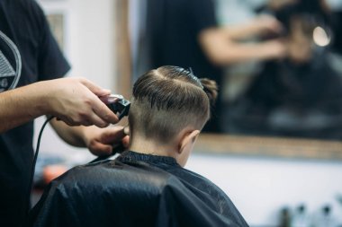 Küçük çocuk saç kesimi tarafından Kuaför Berber Dükkanı, sandalyede otururken Başlarken.