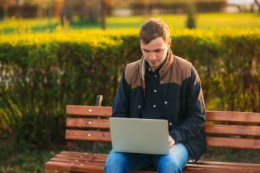 Parkta bir dizüstü bilgisayar üzerinde çalışan genç Yöneticisi. Öğle yemeği molası.