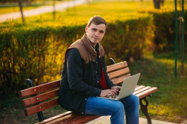 Parkta bir dizüstü bilgisayar üzerinde çalışan genç Yöneticisi. Öğle yemeği molası.