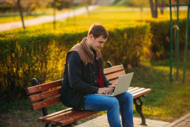 Parkta bir dizüstü bilgisayar üzerinde çalışan genç Yöneticisi. Öğle yemeği molası.