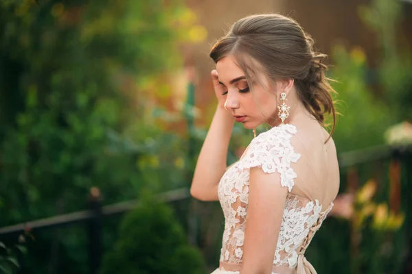 Νεαρή κοπέλα σε γάμο φόρεμα στο πάρκο θέτοντας για φωτογράφο. πορτρέτο — Φωτογραφία Αρχείου