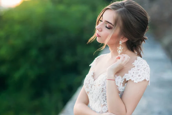 Chica joven en vestido de novia en el fondo de la ciudad al atardecer . — Foto de Stock