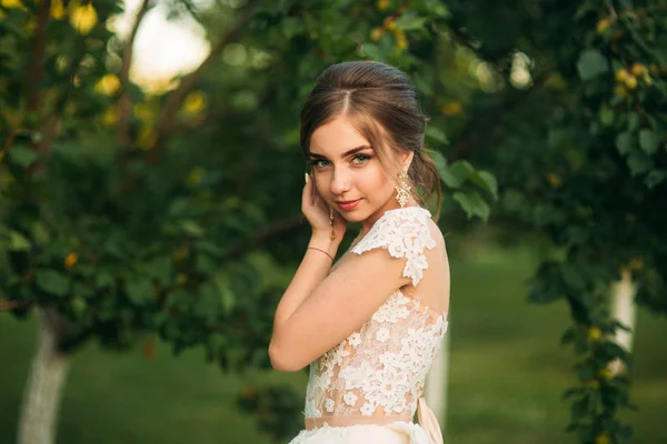 Chica joven en vestido de novia en el parque posando para el fotógrafo. retrato —  Fotos de Stock