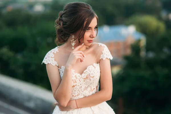 Chica joven en vestido de novia en el fondo de la ciudad al atardecer . — Foto de Stock