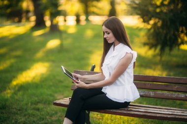 İş kadını bir tablet parkta bir mola sırasında kullanır