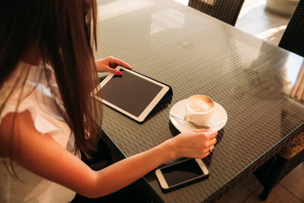 Zakelijke dame maakt gebruik van een tablet en telefoon te werken. Het meisje in het café lacht — Stockfoto