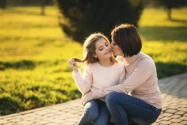 Lille pige med mor gå i parken i efteråret. Golden efterår . - Stock-foto