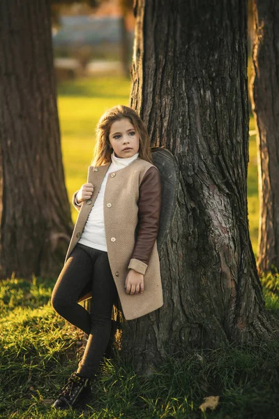 Niña con abrigo de otoño posando para fotógrafo. Otoño dorado . — Foto de Stock