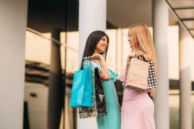 Güzel kızlar alışverişe gideriz. Güneşli bir gün. Yaz.