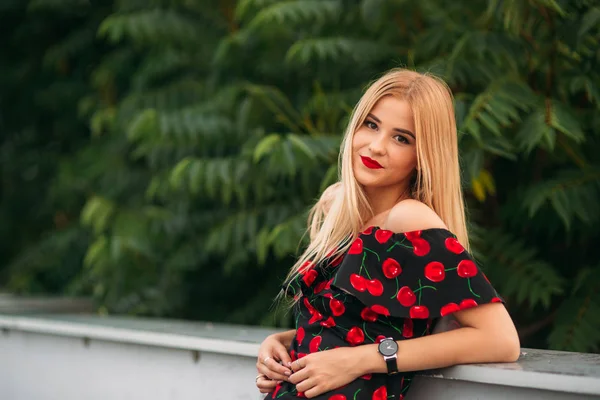 Mooie meisjes poseren voor de fotograaf. Twee zussen in zwarte en rode jurk. Glimlach, zonnige dag, zomer. — Stockfoto