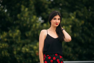 Güzel kızlar fotoğrafçısına poz. Siyah ve Kırmızı elbiseli iki kız kardeş. Gülümse, güneşli gün, yaz.