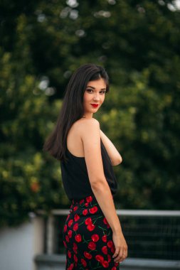 Güzel kızlar fotoğrafçısına poz. Siyah ve Kırmızı elbiseli iki kız kardeş. Gülümse, güneşli gün, yaz.