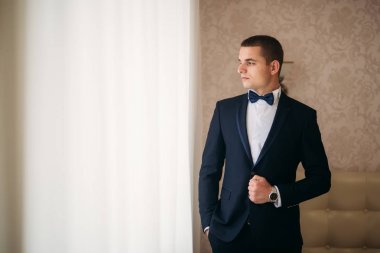 Damat Düğün günde bir koyu takım elbiseli, güneşli bir gün