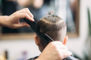 Küçük çocuk saç kesimi tarafından Kuaför Berber Dükkanı, sandalyede otururken Başlarken.