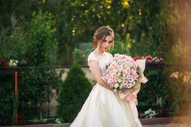 Genç kız gelinlik fotoğrafçısına poz Park. Güneşli havalarda, yaz.