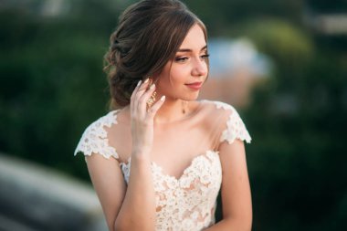 Genç kız gelinlik batımında şehir arka plan üzerinde. Yaz