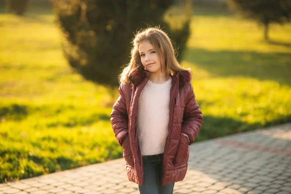 Fetiță în haina de toamnă care pozează pentru fotograf. Toamna de aur . — Fotografie, imagine de stoc