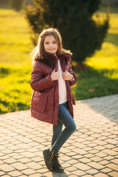Kleines Mädchen im Herbstmantel posiert für Fotografen. Goldener Herbst. — Stockfoto