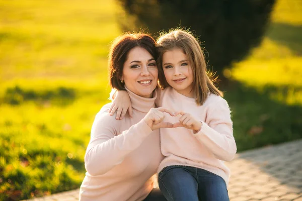 Little girl with mother walking in the park in autumn — Stock Photo, Image