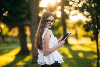 İş kadını bir tablet parkta bir mola sırasında kullanır