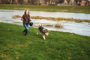 Güzel bir kız set yürüyor. Sarı saçlı ve kahverengi ceket.