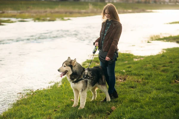 Güzel bir kız set yürüyor. Sarı saçlı ve kahverengi ceket.