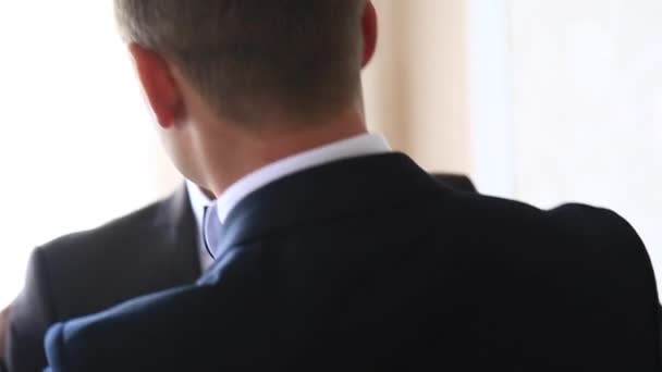 Zieht der mutige Bräutigam seinen Hochzeitsanzug an. Er hält einen Strauß in der Hand. Hochzeitstag. — Stockvideo