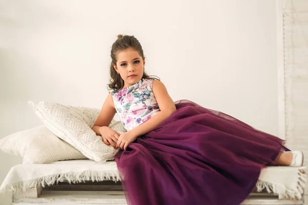 Menina bonita em um vestido roxo e blusa de flor posando para um fotógrafo . — Fotografia de Stock