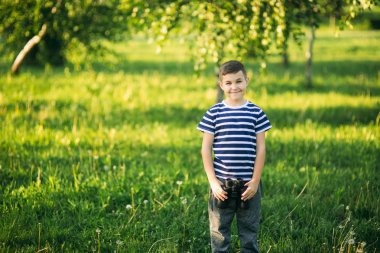 Çizgili bir gömlek küçük çocuk dürbün ile görünüyor. Bahar, güneşli havalarda.