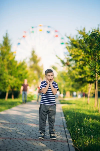 Csíkos póló kisfiú úgy néz ki, keresztül a távcső. Tavasz, napsütés. — Stock Fotó