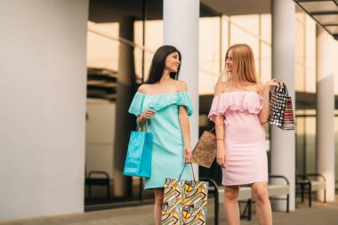 Güzel kızlar alışverişe gideriz. Güneşli bir gün. Yaz.