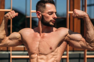 Genç atlet ile bir gövde bir tuğla duvar arka plan fotoğraf için poz. Kurtarma vücut geliştirmeci, atlet pompalanır kaslar, göğüs ve kol ile