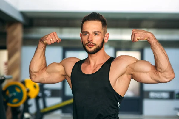 Joven atleta posando con un torso para la fotografía sobre un fondo de pared de ladrillo. Culturista, atleta con músculos bombeados, rescate de mama y brazo —  Fotos de Stock