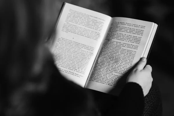 Belle petite fille lit un livre dans la bibliothèque . — Photo