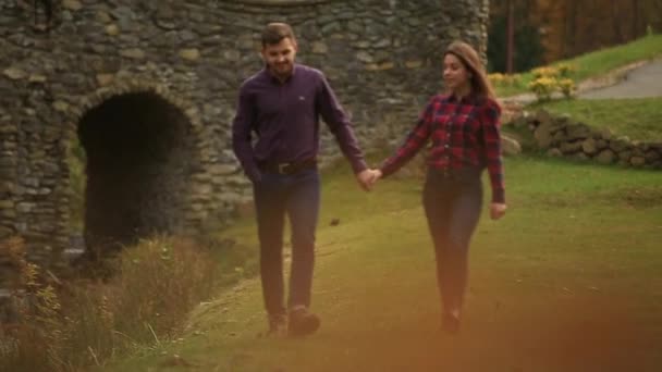 Любящая пара гуляет осенью в парке. История любви в солнечный осенний день . — стоковое видео