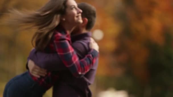 Una pareja amorosa camina en el otoño en el parque. Una historia de amor en un día soleado de otoño. lago y bringe  . — Vídeos de Stock