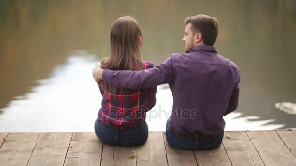 Milující pár se chodí na podzim v parku. Příběh lásky za slunečného podzimního dne. jezero a bringe . — Stock video