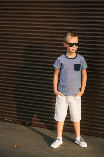 Bel ragazzo sorridente e in posa per il fotografo. Un bambino gioioso passeggia per il parco. Tempo soleggiato estate — Foto Stock