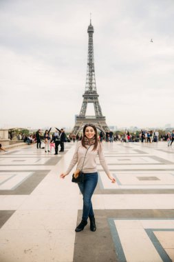 Güzel kız fotoğrafçı Eyfel Kulesi arka planı için poz. Sonbahar photosession. Güneşli havalarda. Güzel gülümseme ve makyaj