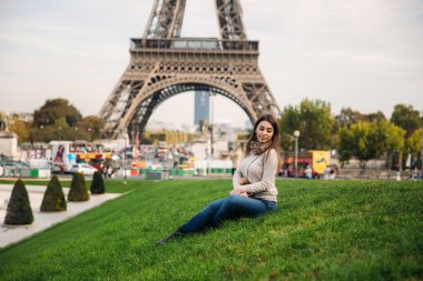 Güzel kız fotoğrafçı Eyfel Kulesi arka planı için poz. Sonbahar photosession. Güneşli havalarda. Güzel gülümseme ve makyaj