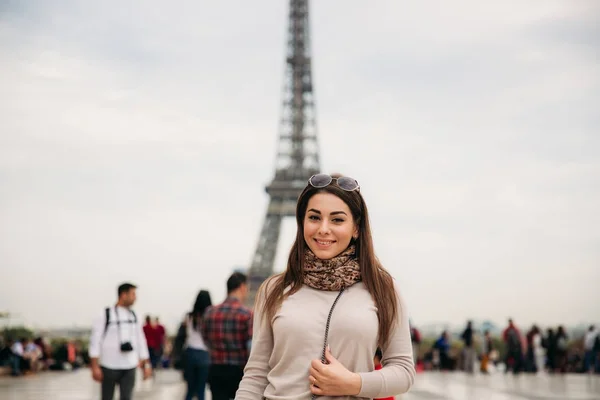 Menina bonita posando para o fotógrafo contra o fundo da Torre Eiffel. Fotosessão de Outono. Tempo ensolarado. Belo sorriso e maquiagem — Fotografia de Stock
