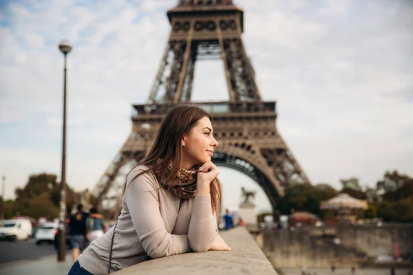 Όμορφη κοπέλα ποζάρει στο φωτογράφο φόντο τον Πύργο του Άιφελ. Φθινόπωρο photosession. Ηλιόλουστος καιρός. Όμορφο χαμόγελο και μακιγιάζ — Φωτογραφία Αρχείου
