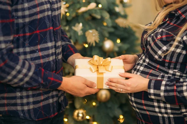 Genç bir çift bir hediye tutuyor. Noel ruh hali ve tatil hediye