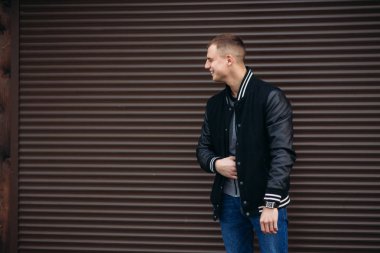 Koyu çizgili duvarlarının poz ve fotoğrafçı gülümseyen bir arka plan siyah ceketli genç bir adam