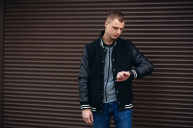 Koyu çizgili duvarlarının poz ve fotoğrafçı gülümseyen bir arka plan siyah ceketli genç bir adam