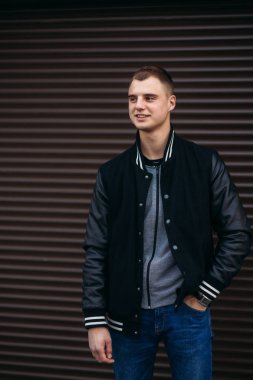 Koyu çizgili duvarlarının poz ve fotoğrafçı gülümseyen bir arka plan siyah ceketli genç bir adam